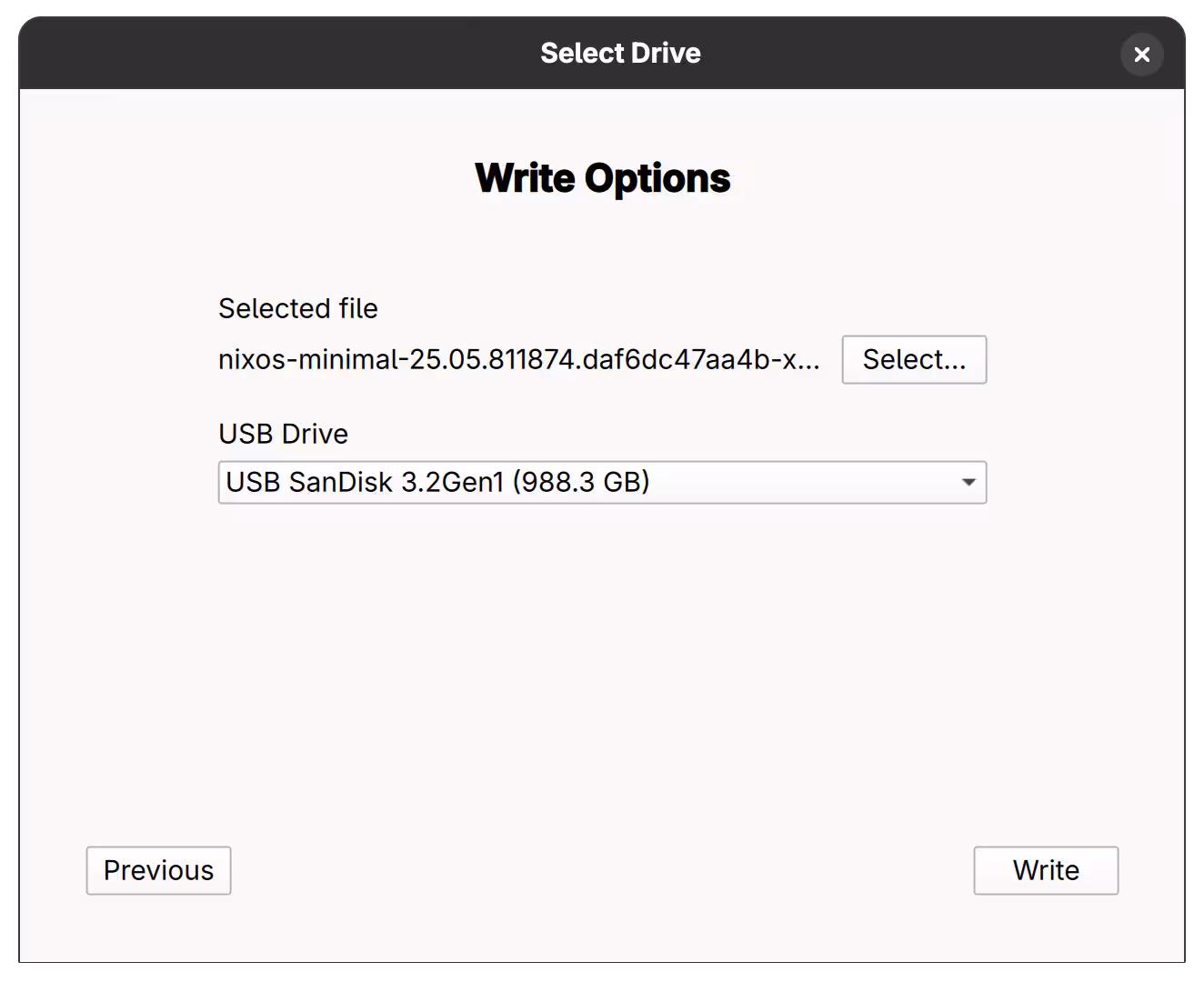 Writing the image A dialog for choosing "Write Options" at Fedora Media Writer. A file named "nixos-minimal-25.05.811874.daf6dc47aa4b-x86_64-linux.iso" is selected, and "USB SanDisk 3.2Gen1 (988.3 GB)" is selected as a USB Drive.
