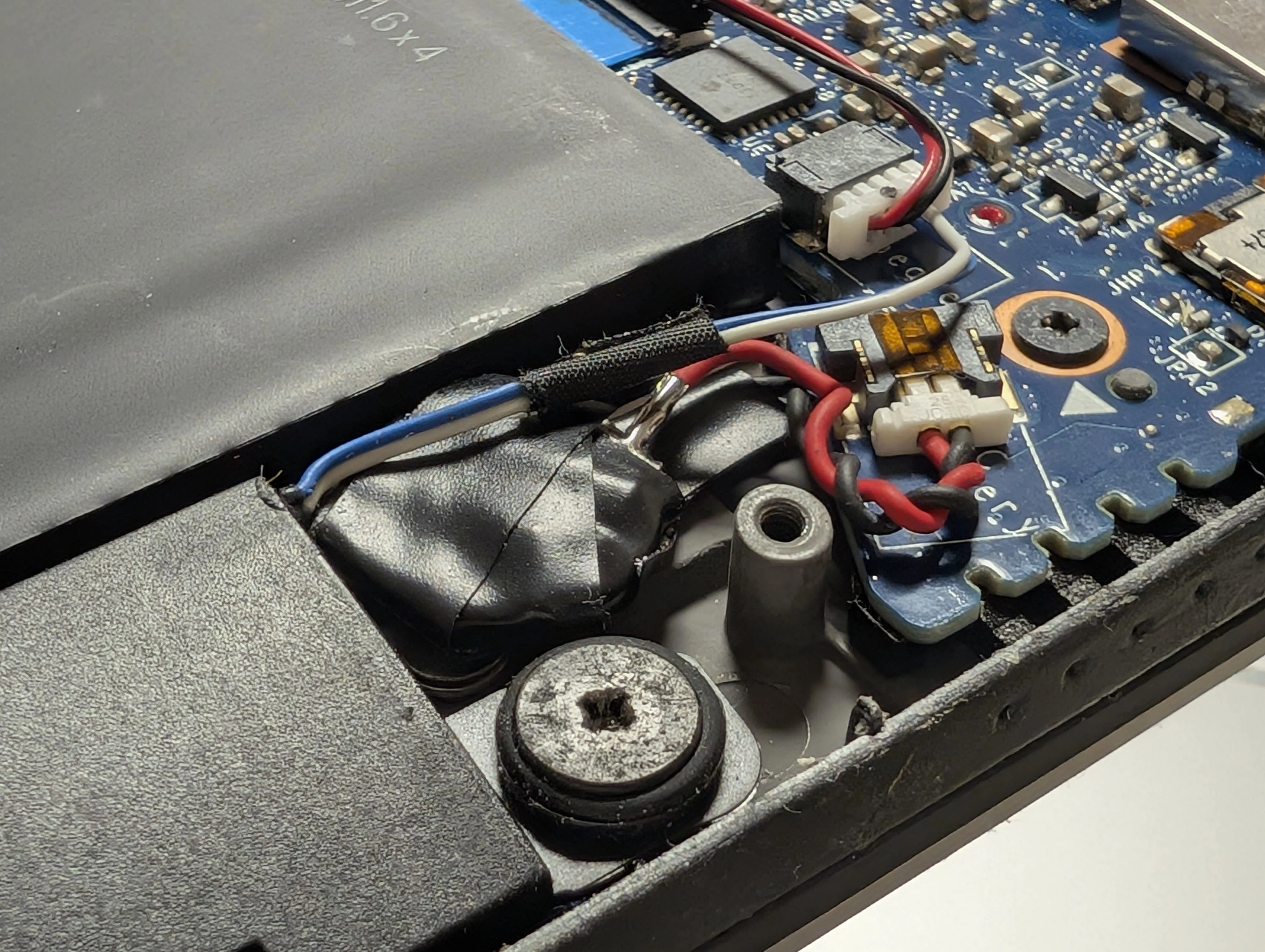 The RTC battery, with the cell wrapped with electrical tape, plugged in to the mainboard